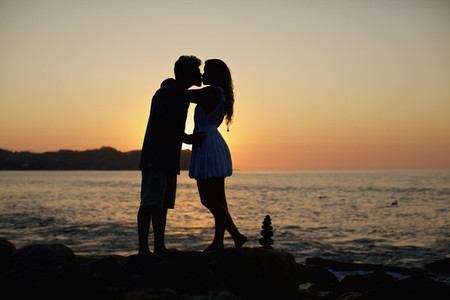 Silhouette young  romantic couple kissing on idyllic beach at sunset 01