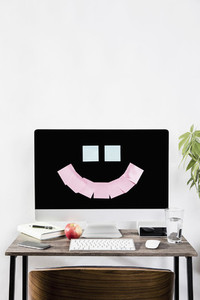 Adhesive notes forming smiley face on computer in office 01
