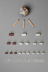 View form above rubber band ball  pencils  binder clips and paper clips on gray background 01