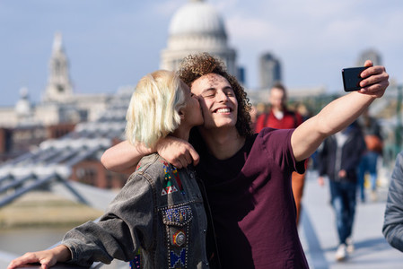 Happy couple taking a selfie photograph on Londons Millennium Bridge
