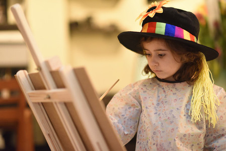 Little girl painting a picture at home