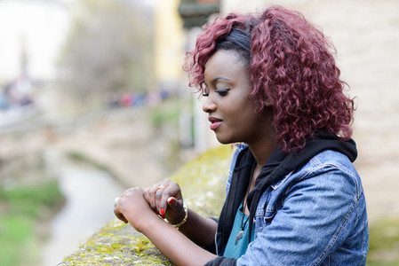 Beautiful black woman in urban background with red hair