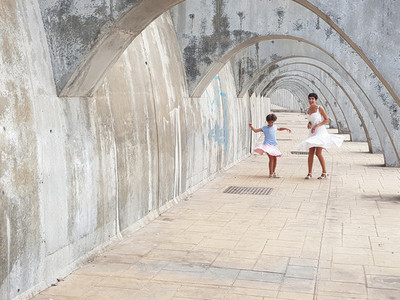 Mother and daughter dancing under the arches of the Port of Mala