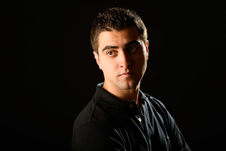 Young casual man on black background