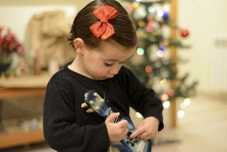 Little girl at home with decoration and defocused Christmas ligh