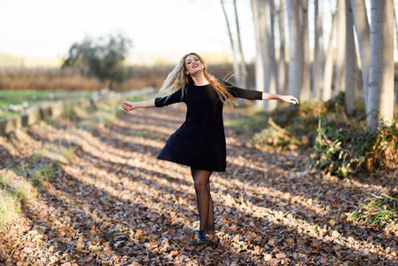 Young blonde woman dancing in poplar forest