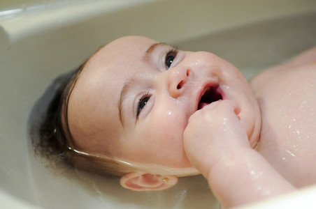 Baby girl four months old having her bath