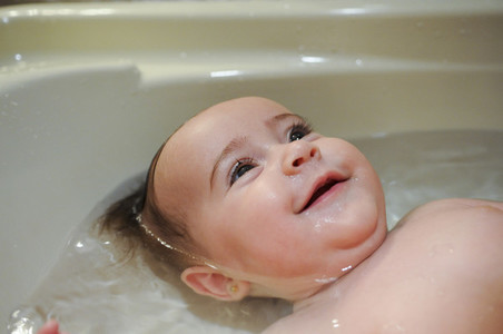 Baby girl four months old having her bath