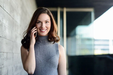 Businesswoman talking with a smartphone in an office building