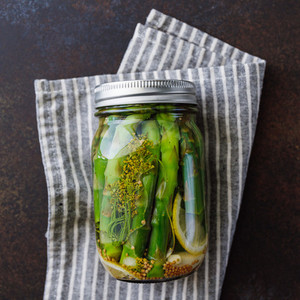 Top view of pickled asparagus in a jar Seasonal canning vegetable recipe