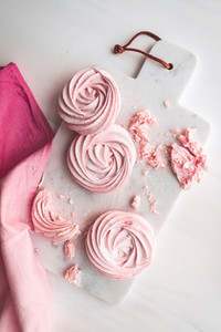 Top view of pink meringue on a white marble tray Flat lay composition