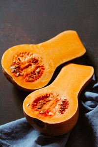 View on raw halves of butternut squash on a kitchen table Seasonal vegetable food still life