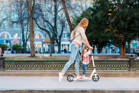 Mom and little daughter on a scooter