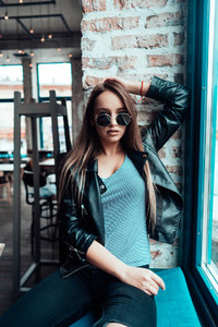 Beautiful girl in sunglasses posing on camera