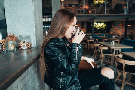 Beautiful girl in a black jacket in a cafe