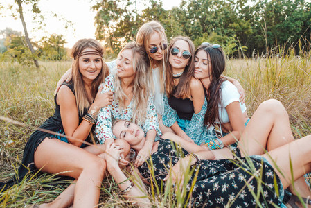 Six girls in nature are sitting on the grass