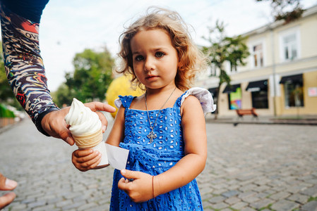 Beautiful little girl holds ice cream