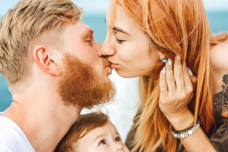 Mom and Dad kiss Happy family on vacation