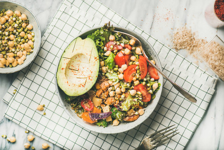 Vegan dinner bowl with avocado  grains  beans and vegetables