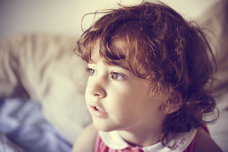 Adorable little girl with curly hair tousled