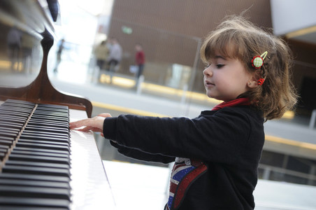 little girl having fun playing the piano