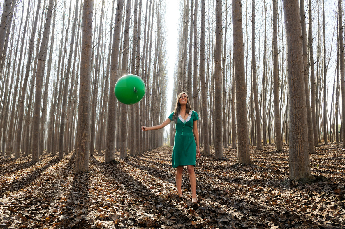 Beautiful blonde girl  dressed in green  walking into the forest
