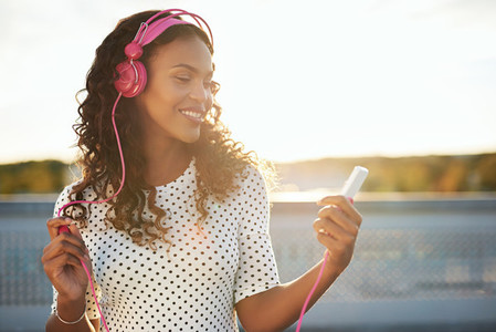 Lady listening to music in pink headphones