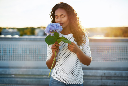 Black woman smelling a pretty flower