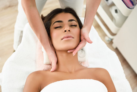 Woman receiving head massage in spa wellness center