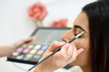 Makeup artist putting make up on an womans eyebrows
