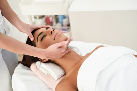 Woman receiving head massage in spa wellness center