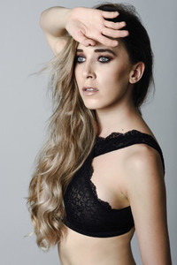 Woman with long hair and blue eyes wearing black lingerie