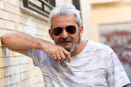Mature man smiling with aviator sunglasses in urban background