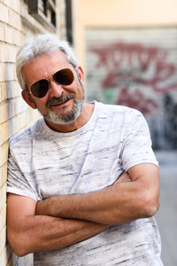 Mature man smiling with aviator sunglasses in urban background