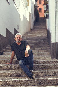 Mature man sitting on steps in urban background