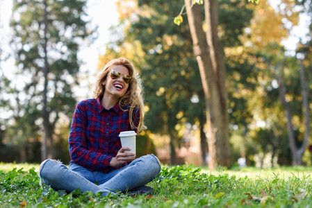 Beautiful woman drinking coffee in the park