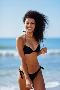 Young arabic woman with beautiful body in swimwear smiling on a