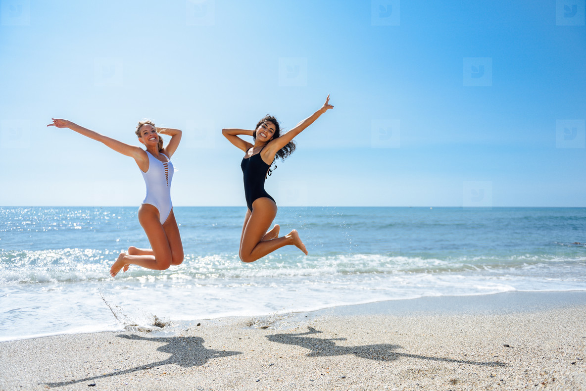 Two funny girls in swimsuit jumping on a tropical beach stock photo  (182708) - YouWorkForThem