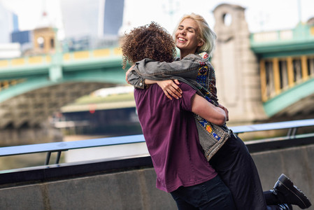 Happy couple hugging near the Southwark bridge over River Thames London