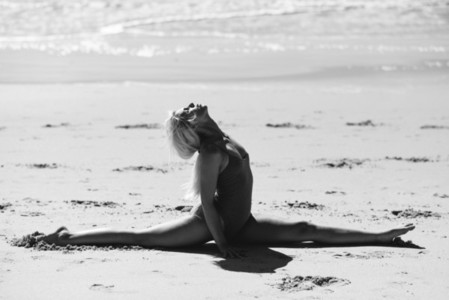 Caucasian blonde woman practicing yoga in the beach
