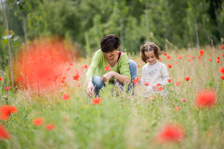 Mother with her little daughter in poppy field