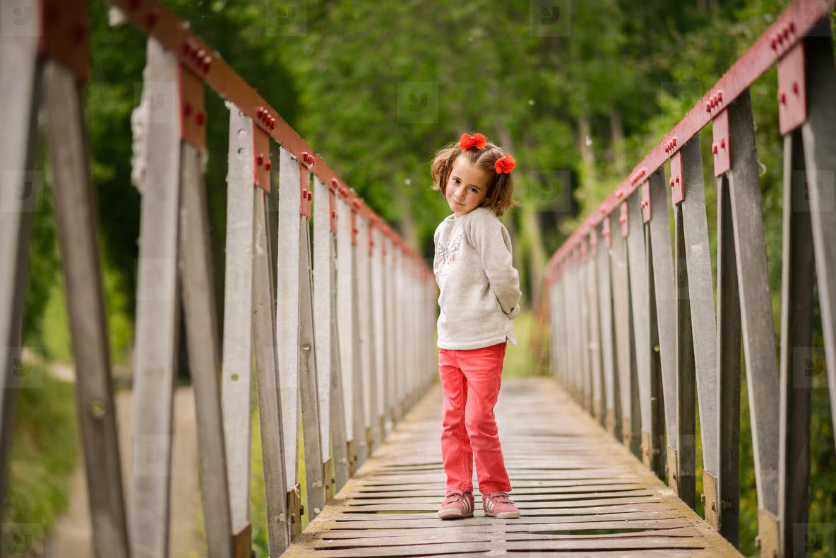 Cute little girl having fun in a rural bridge