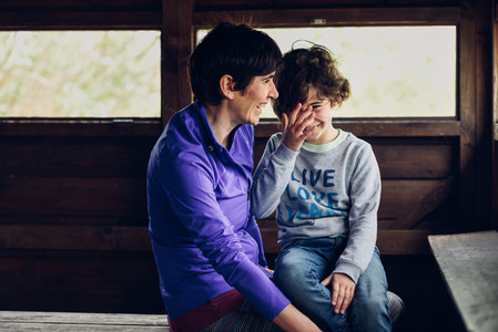 Mother with her seven year old daughter laughing in a cabin in t