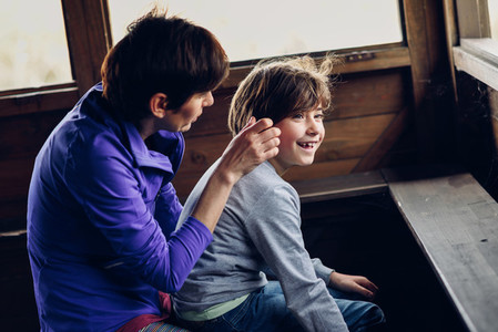 Mother with her seven year old daughter laughing in a cabin in t