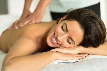 Young female receiving a relaxing back massage in a spa center