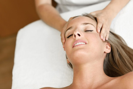 Young woman receiving a head massage in a spa center