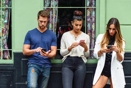 Multiracial group of people looking down at smart phone