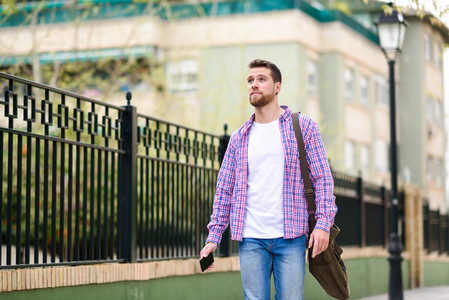 Young bearded man walking in urban background Lifestyle concept