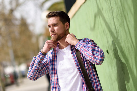 Attractive young man standing in urban background Lifestyle con