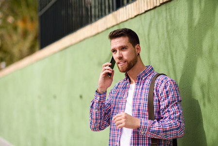 Young man talking with his smart phone in urban background  Life